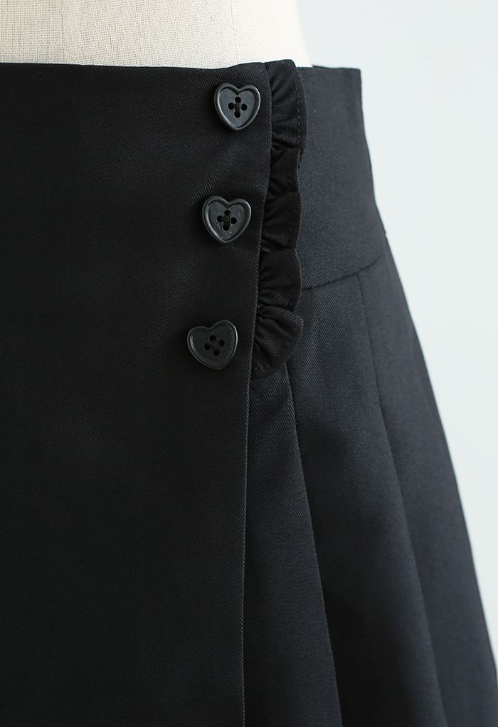 تنورة صغيرة مطوية بأزرار على شكل قلب باللون الأسود