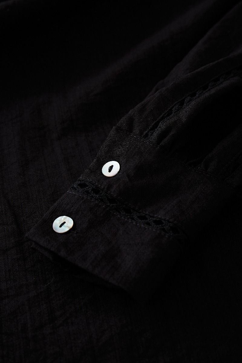 طقم قميص بشرابة مفرغة وتنورة صغيرة متدرجة باللون الأسود