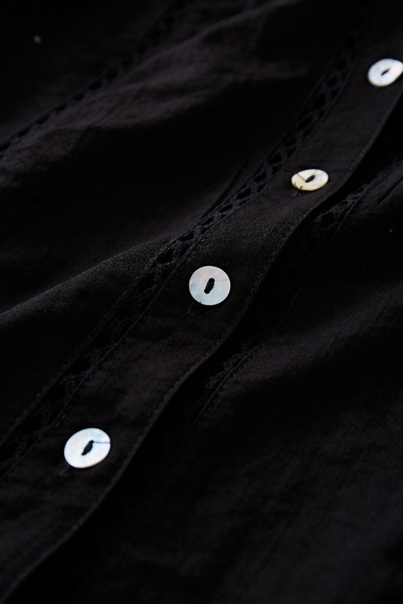 طقم قميص بشرابة مفرغة وتنورة صغيرة متدرجة باللون الأسود
